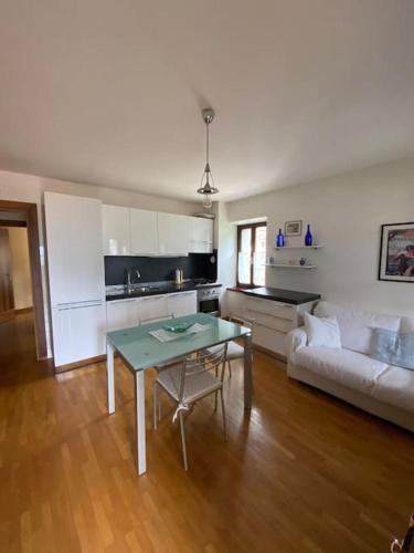 een woonkamer met een tafel en een bank bij Il tuo nido sulle Dolomiti, con vista panoramica! in Calalzo