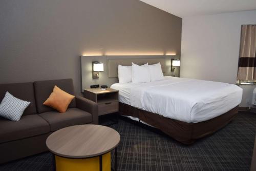 Habitación de hotel con cama y sofá en Comfort Inn & Suites Syracuse-Carrier Circle en East Syracuse