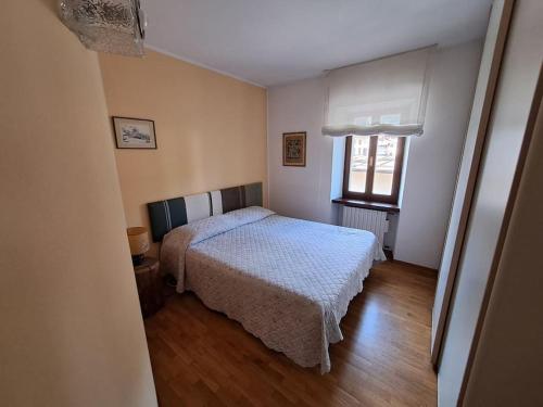een slaapkamer met een bed en een raam bij Il tuo nido sulle Dolomiti, con vista panoramica! in Calalzo