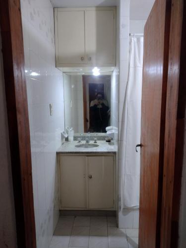 een badkamer met een wastafel en een spiegel bij La Casa de Ana in San Antonio de Areco