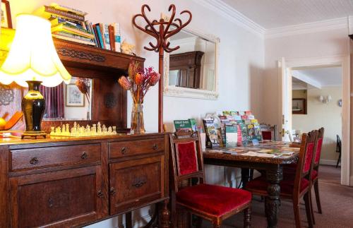 a dining room with a table and a desk with chairs at Kersbrook Guest Accommodation in Lyme Regis