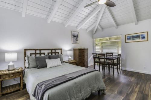a bedroom with a bed and a table and chairs at Sandpiper 216B condo in Princeville