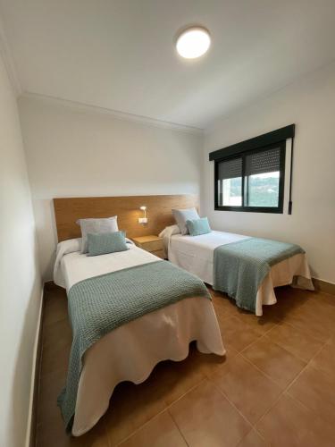 ein Schlafzimmer mit zwei Betten und einem Fenster in der Unterkunft LA CASA DE DORA EN LA ESCUSA in Armentera