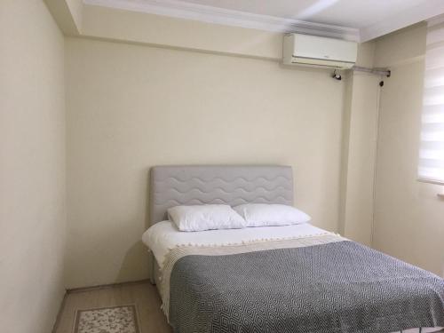 1 dormitorio con 1 cama en una habitación con ventana en Site daire, en Arsin