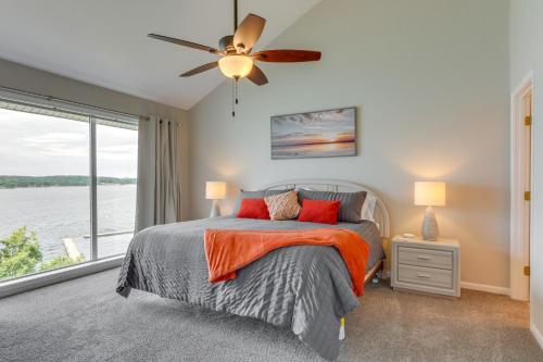 a bedroom with a bed and a large window at Lakefront Ozark Getaway with Views and Community Perks in Four Seasons