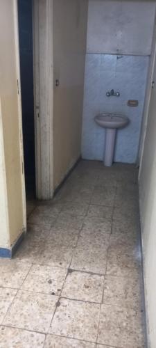 a bathroom with a sink and a tiled floor at طنطا أول طريق شوبر in Quḩāfah