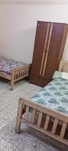 Cette chambre comprend 2 lits et des placards en bois. dans l'établissement طنطا أول طريق شوبر, à Quḩāfah