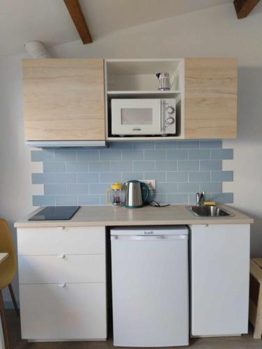 a small kitchen with a sink and a microwave at Maria Sardinha_As Três Marias in Matosinhos