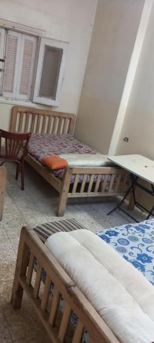 a room with two beds and a table in it at طنطا أول طريق شوبر in Quḩāfah