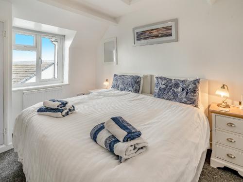 ein Schlafzimmer mit einem großen weißen Bett mit Handtüchern darauf in der Unterkunft Stable Cottage - Uk10694 in Amroth