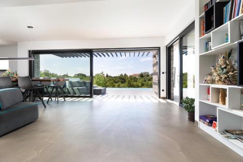 a living room with a large glass door and a dining room at Cà Veia in Vrbnik