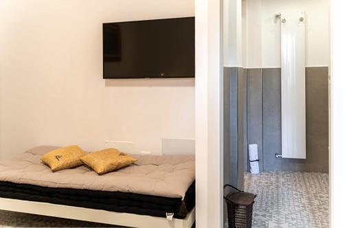 a bedroom with a bed with a flat screen tv on the wall at Suite Mariagiovanni in Lecce