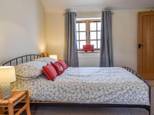 Un dormitorio con una cama con almohadas rojas. en The Potting Shed en Par