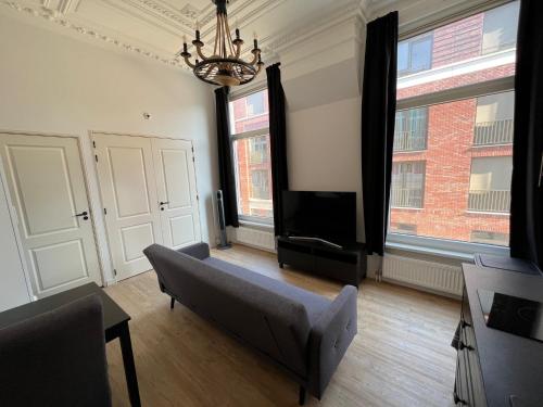 a living room with a couch and a flat screen tv at MyCityLofts in Rotterdam