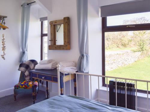 una camera con letto, specchio e finestra di Ty Newydd a Llandwrog