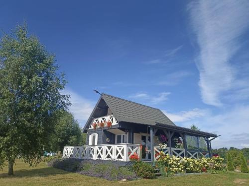 a black house with a white fence around it at Domek Lawendowe Wzgórze in Mielenko