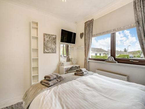 a bedroom with a large bed and a window at Highview in Brodick