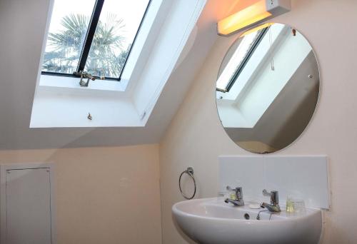 a bathroom with a sink and a mirror at Kersbrook Guest Accommodation in Lyme Regis