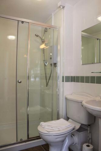 a bathroom with a shower and a toilet and a sink at Kersbrook Guest Accommodation in Lyme Regis