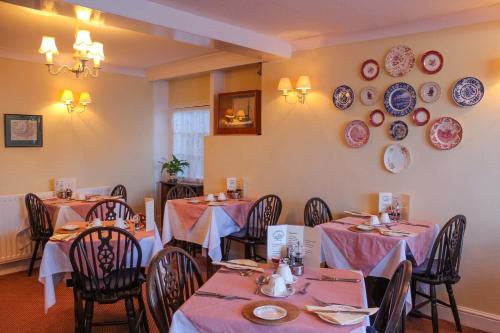 a dining room with tables and plates on the wall at Kersbrook Guest Accommodation in Lyme Regis