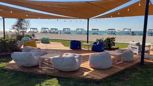 a group of white chairs and tables under a tent at the beach at North coast Sedra Resort Chalet قريه سيدرا الساحل الشمالي علي البحر شاليه ثلاث غرف in Alexandria