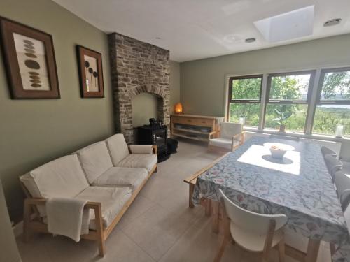 a living room with a table and a couch at Blue Stack View in Edergole Bridge