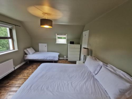 a bedroom with two white beds and a window at Blue Stack View 