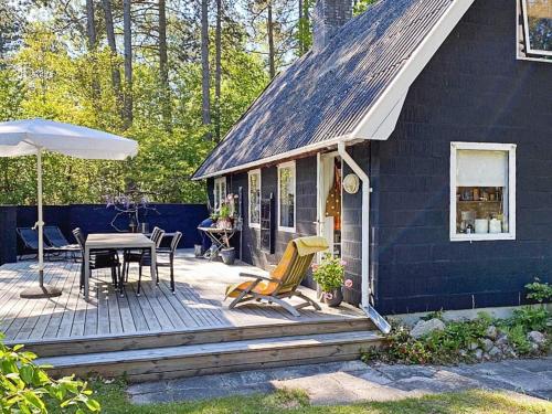 uma casa azul com um deque com uma mesa e cadeiras em 6 person holiday home in Nyk bing Sj em Rørvig
