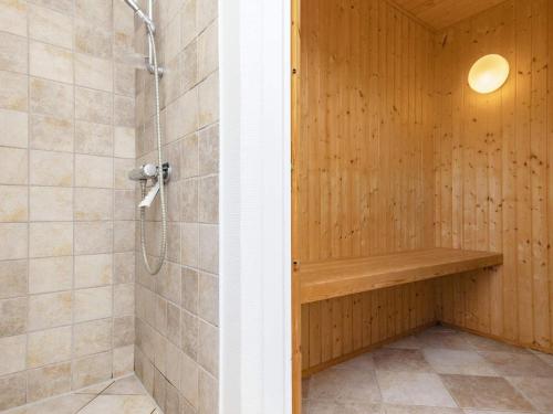 y baño con ducha y pared de madera. en Holiday Home Kallesensvej, en Blåvand