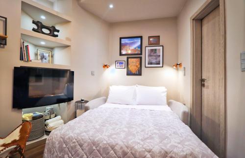 a bedroom with a bed and a flat screen tv at Modern Studio in Vibrant Kolonaki Area in Athens