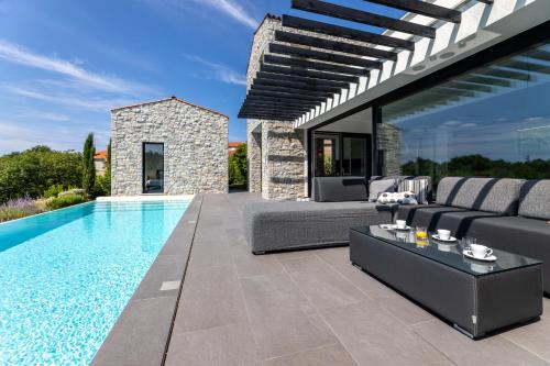 a swimming pool in a villa with a couch at Cà Veia in Vrbnik