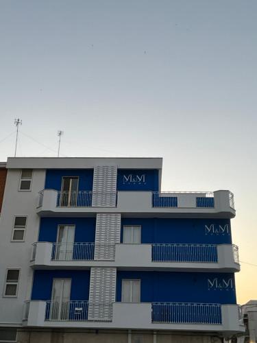 an apartment building with blue balconies at M&M rooms Margherita di Savoia in Margherita di Savoia
