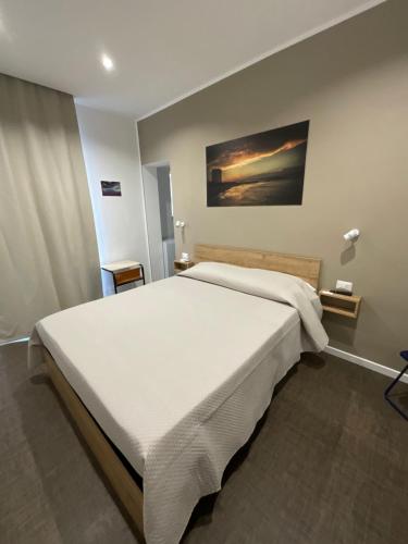 a bedroom with a large white bed in a room at M&M rooms Margherita di Savoia in Margherita di Savoia