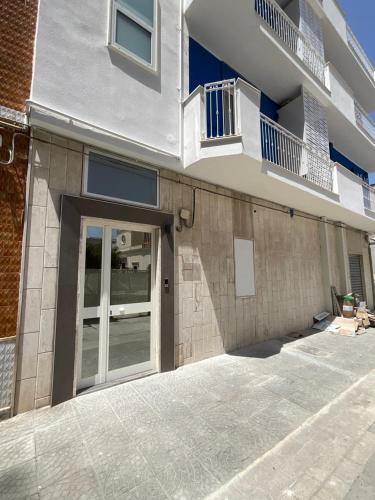 a building with a door and a balcony at M&M rooms Margherita di Savoia in Margherita di Savoia