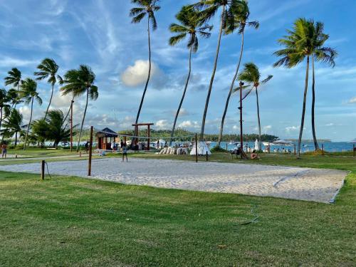 un parque con palmeras y un parque infantil en Flat Eco Resort Carneiros, en Praia dos Carneiros