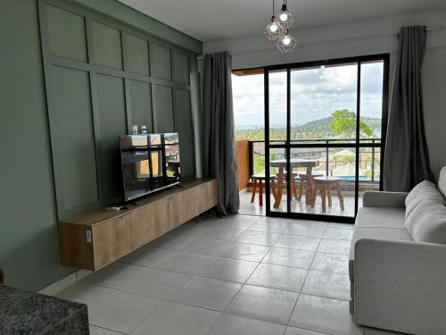 un soggiorno con divano e vista su un patio di Flat Eco Resort Carneiros a Praia dos Carneiros