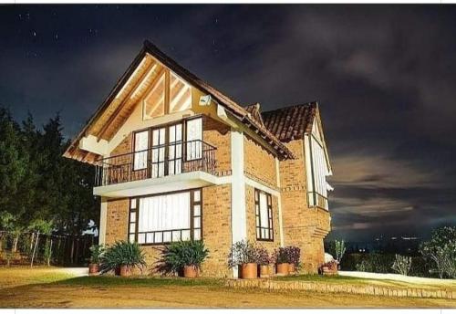 una gran casa de ladrillo con un cielo oscuro en Cabaña Campestre el Refugio en Villa de Leyva