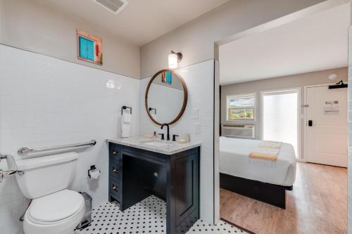 a bathroom with a toilet and a sink and a mirror at Taos Motor Lodge in Taos