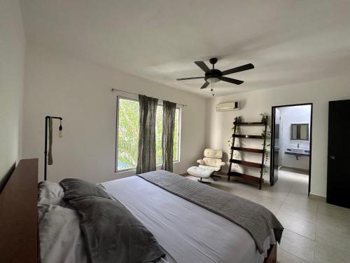 een slaapkamer met een bed en een plafondventilator bij Zen Home, Private community, Wifi, Free Private Parking, Balcony in Tulum