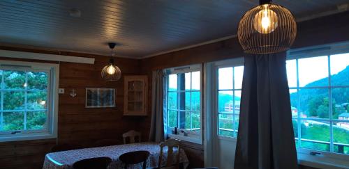 a bedroom with windows and a table with chairs at Stalheim Fjord og Fjellhytter in Stalheim
