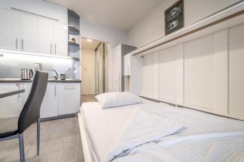 a bedroom with white cabinets and a bed and a chair at Rezidencia pri Radnici in Košice