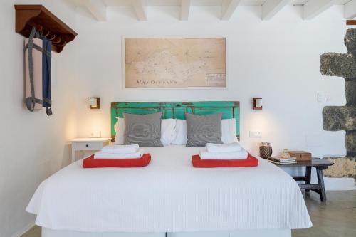 a bedroom with a white bed with two red pillows at Eco Living Olivos76 in Tías