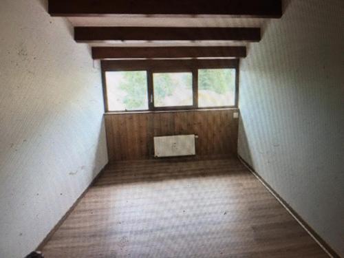 um quarto vazio com uma janela e um piso de madeira em Château de la touche em Savigny-Lévescault