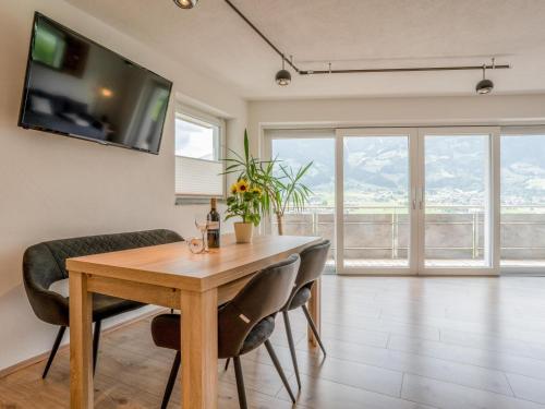 a dining room table with chairs and a television on the wall at Josef Konrad in Helfenstein