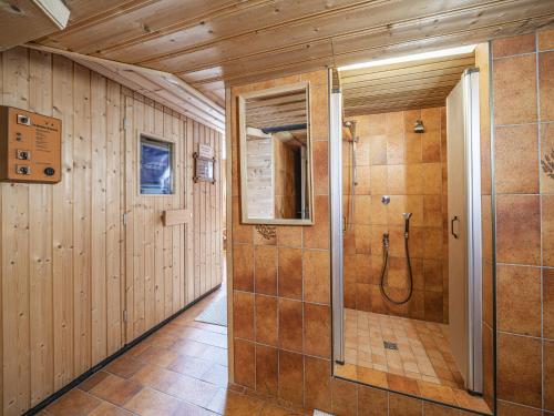 a walk in shower in a bathroom with wooden walls at Maria Rose XXL in Kirchberg in Tirol