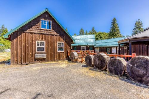a wooden barn with logs in front of it at The Logs Deer Room in Snowden