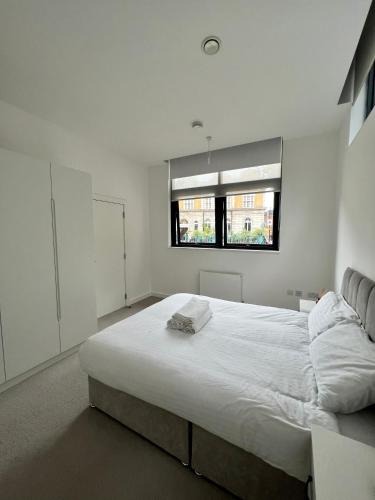 a bedroom with a large white bed with a window at Luxury Modern 1 Bed Apartment in London