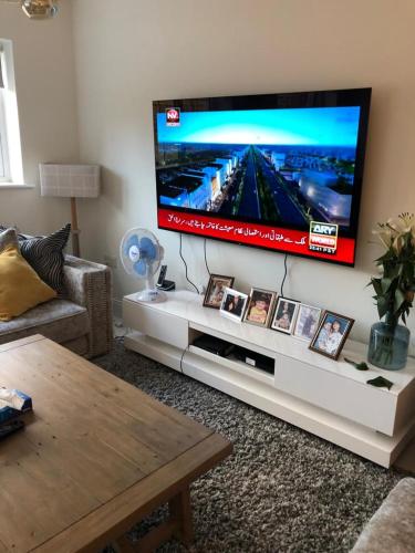 ein Wohnzimmer mit einem großen Flachbild-TV an der Wand in der Unterkunft Croydon Near London in Shirley