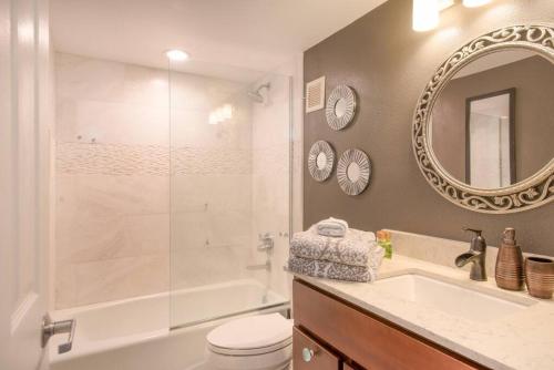 a bathroom with a shower and a toilet and a sink at White Sands Village, Gorgeous 2BR, Top/Front Bldg in Kailua-Kona