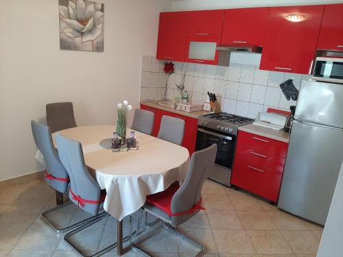eine Küche mit einem Tisch mit Stühlen und einem Kühlschrank in der Unterkunft Apartments with a parking space Vrsi, Zadar - 14211 in Vrsi